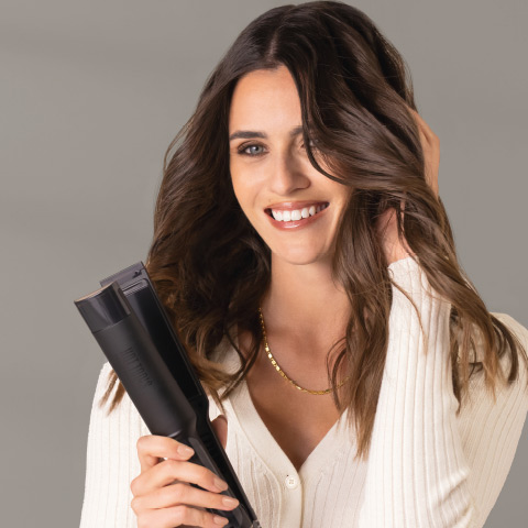 Frau beim Styling mit einem Hot Tools Glätteisen.