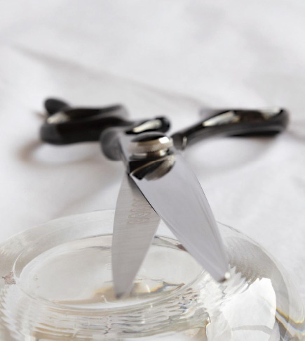 Detailaufnahme einer Line Scissors Haarschere auf Glasblock.