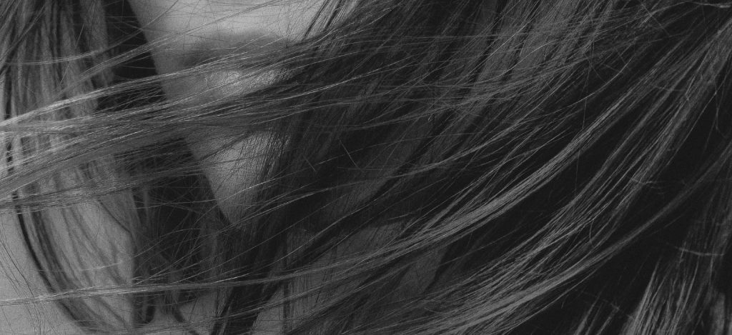 Frau mit wehendem Haar in schwarz-weiß – Hero-Bild der Seite „Karriere“.